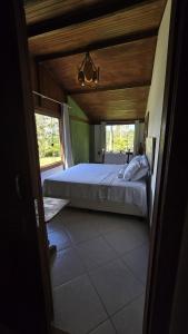 a bedroom with a large bed with a wooden ceiling at Chalé Vista Pedra Azul in Domingos Martins