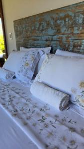 a bed with white sheets and pillows on it at Chalé Vista Pedra Azul in Domingos Martins