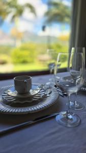 a table with a plate and a cup and a glass at Chalé Vista Pedra Azul in Domingos Martins