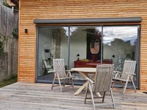 a patio with a table and three chairs on a deck at Joes Cottage in Lackenbach