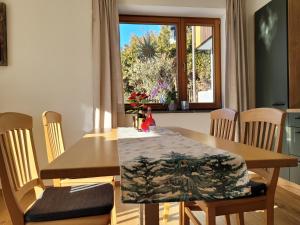 a dining room with a table and chairs and a window at Ferienwohnung Obstgarten in Halblech
