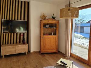 a living room with a television and a wooden cabinet at Ferienwohnung Obstgarten in Halblech