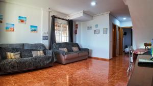 a living room with two chairs and a couch at Apartalux Playa Paraíso in La Manga del Mar Menor +59 photos