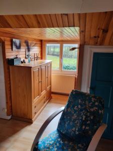a living room with a chair and a sink at Chambres à l'Orée du bois in Souancé-au-Perche