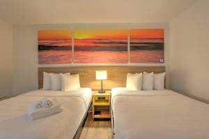 two beds sitting next to each other in a room at Hotel Carolina in Hilton Head Island