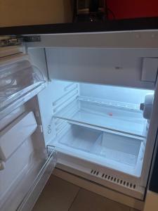 an empty refrigerator with its door open and its door at Trafford Sky Homes Leipzig City - 5 Min to Hauptbahnhof Nikolaistrasse in Leipzig