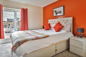 a bedroom with a bed with an orange wall at Beautiful City Centre House with Parking! Sleeps 6 in Sheffield