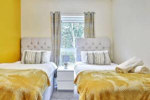 a bedroom with two beds and a window at Beautiful City Centre House with Parking! Sleeps 6 in Sheffield +8 photos