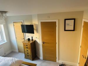 a bedroom with a bed and a television on the wall at GR8 Home in Kingsley