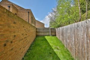 a brick wall next to a wooden fence at Beautiful City Centre House with Parking! Sleeps 6 in Sheffield