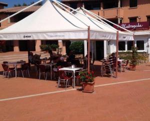 a white tent with tables and chairs in front of a building at Tortuga Smeralda in Porto Rotondo