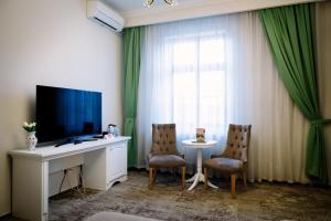 a room with a desk with a television and two chairs at Hotel-Restaurant La Belle Epoque in Petroşani