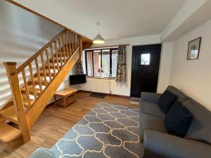 a living room with a couch and a staircase at Millbrook House Apartments 4 in Milton