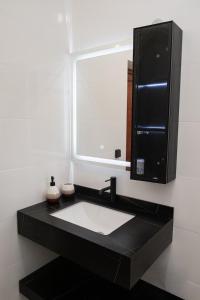 a bathroom with a sink and a mirror at T3 Elegance x Nawassi Moderne, climatisé, sécure in Pamandzi
