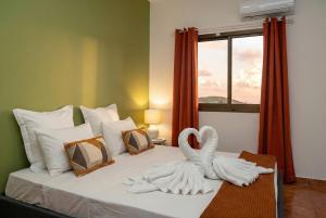 a bed with two swans towels sitting on it at T3 Elegance x Nawassi Moderne, climatisé, sécure in Pamandzi