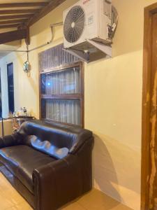 a living room with a couch and a fan at Sadewa homestay batukaras in Batukaras