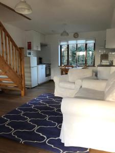 a living room with white furniture and a blue rug at Millbrook House Apartments 3 in Milton