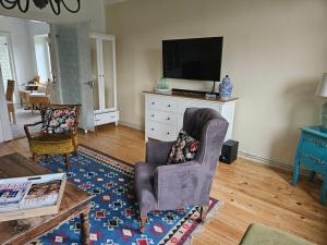 a living room with a chair and a tv at Joes Cottage in Lackenbach