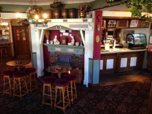 a restaurant with a bar with stools and a fireplace at The Stockton Arms in Stockton-on-Tees