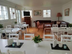 a dining room with white tables and chairs at Stege Nor in Stege