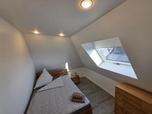 a attic bedroom with a bed and a window at Handwerkerwohnung, Monteurunterkunft-Rodgau in Rodgau