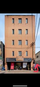 a tall brown building with a sign in front of it at ライズ201 in Kasugai