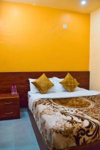 a bedroom with a bed with a yellow wall at Hotel Sawai View in Sawāi Mādhopur