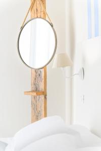a mirror hanging on a wooden pole next to a bed at Hotel Nobel in Gabicce Mare