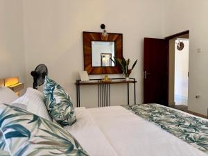 a bedroom with a white bed and a mirror at Dark Green Resort - Airport Transit Villa in Negombo