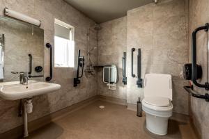 a bathroom with a toilet and a sink at Maison des Landes - Accessible Hotel in St. Ouen's