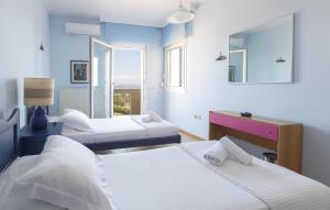 a bedroom with two beds and a mirror at Chios Seafront Luxury Villa with Pool in Chios