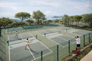 a group of people playing tennis on a tennis court at Versants - La Croix Valmer in La Croix-Valmer