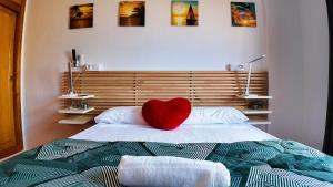 a red heart pillow sitting on top of a bed at Apartalux Vista Mar in La Manga del Mar Menor