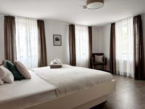 a bedroom with a large white bed with windows at Adler Hotel und Restaurant Schiltach in Schiltach