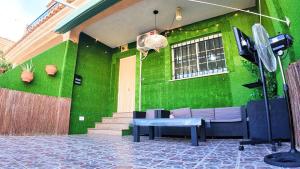 a green building with a couch and a table in front at Apartalux Vista Mar in La Manga del Mar Menor