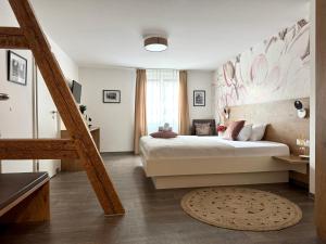 a bedroom with a large bed and a staircase at Adler Hotel und Restaurant Schiltach in Schiltach