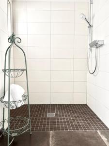 a shower in a bathroom with white tiles at Adler Hotel und Restaurant Schiltach in Schiltach