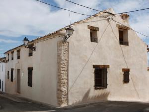 a white building with windows on the side of it at Casa Rural El Acebo in Almodóvar del Pinar