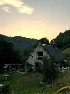 an old stone house with a thatched roof at La grange du Taillat in Campan