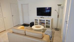 a living room with a couch and a flat screen tv at Lillstugan i Rasbo in Uppsala