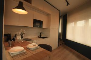 a kitchen with a wooden table with plates and wine glasses at Casa dos Americanos - Suite Wellness in Briño +13 photos