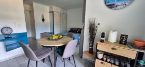 a kitchen with a table with chairs and a bowl of fruit at TOUMALACAÏ Appart 245 in Folle Anse