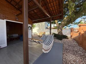 a hammock on a patio under a roof at Gastehaus Watzko in Piçarras