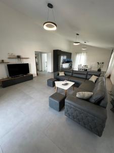 a living room with a couch and a table at Modern Getaway Meets Nature in Ishull-Shëngjini