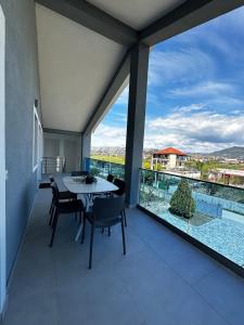 a balcony with a table and chairs and a large window at Modern Getaway Meets Nature in Ishull-Shëngjini