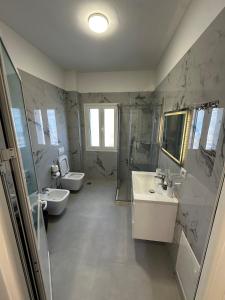 a bathroom with two sinks and a shower and two toilets at Modern Getaway Meets Nature in Ishull-Shëngjini +13 photos