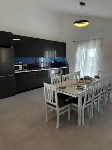 a dining room with a white table and white chairs at Modern Getaway Meets Nature in Ishull-Shëngjini