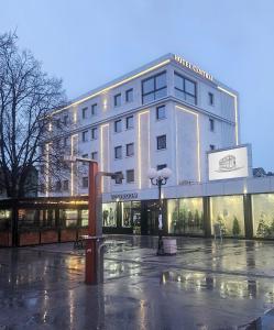 a building on a rainy street in front at Hotel Central in Inđija