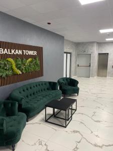 a living room with green couches and a table at BALKAN TOWER- Apartment Viktoria in Gabrovo