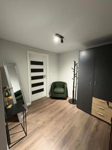 a living room with a green chair and a mirror at BALKAN TOWER- Apartment Viktoria in Gabrovo